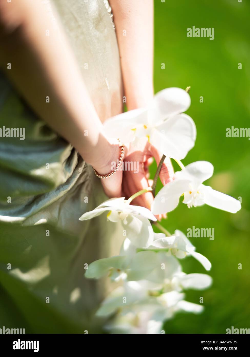 Elegant White Orchid Portrait – Back-Facing Model with Shallow Depth Floral Focus and Vibrant Green Background for Editorial Art